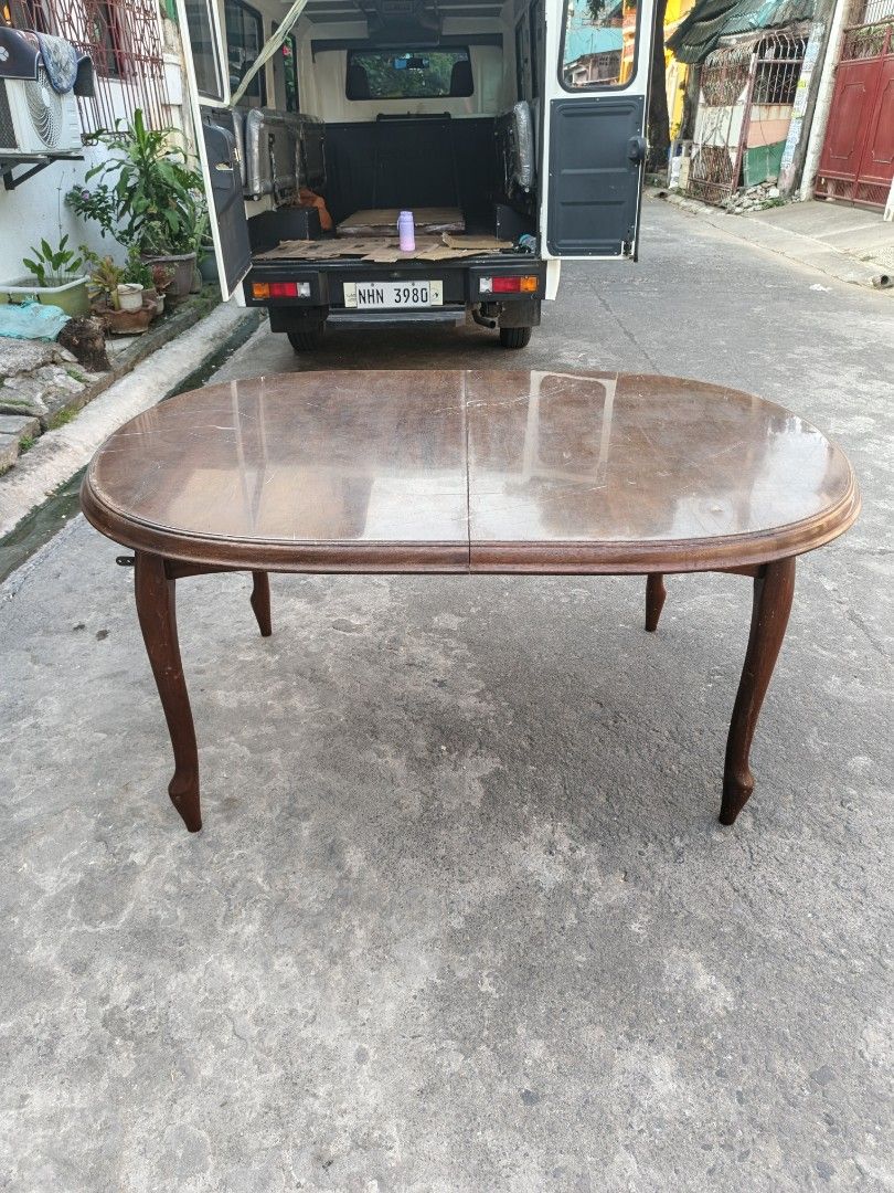 Extendable Oval Dining Table - Dark Wood (Category: Tables & Sets) located in Manila. Submitted by tonyhawk0592 (Listing ID 1445291870, Image 2). Description: - Oval dining table with extendable leaves - Dark wood finish - Seats 4-6 people comfortably - Features unique curved legs - Ideal for smaller dining areas - Minor scuffs on the surface, adding character - Ready for its new home!.
