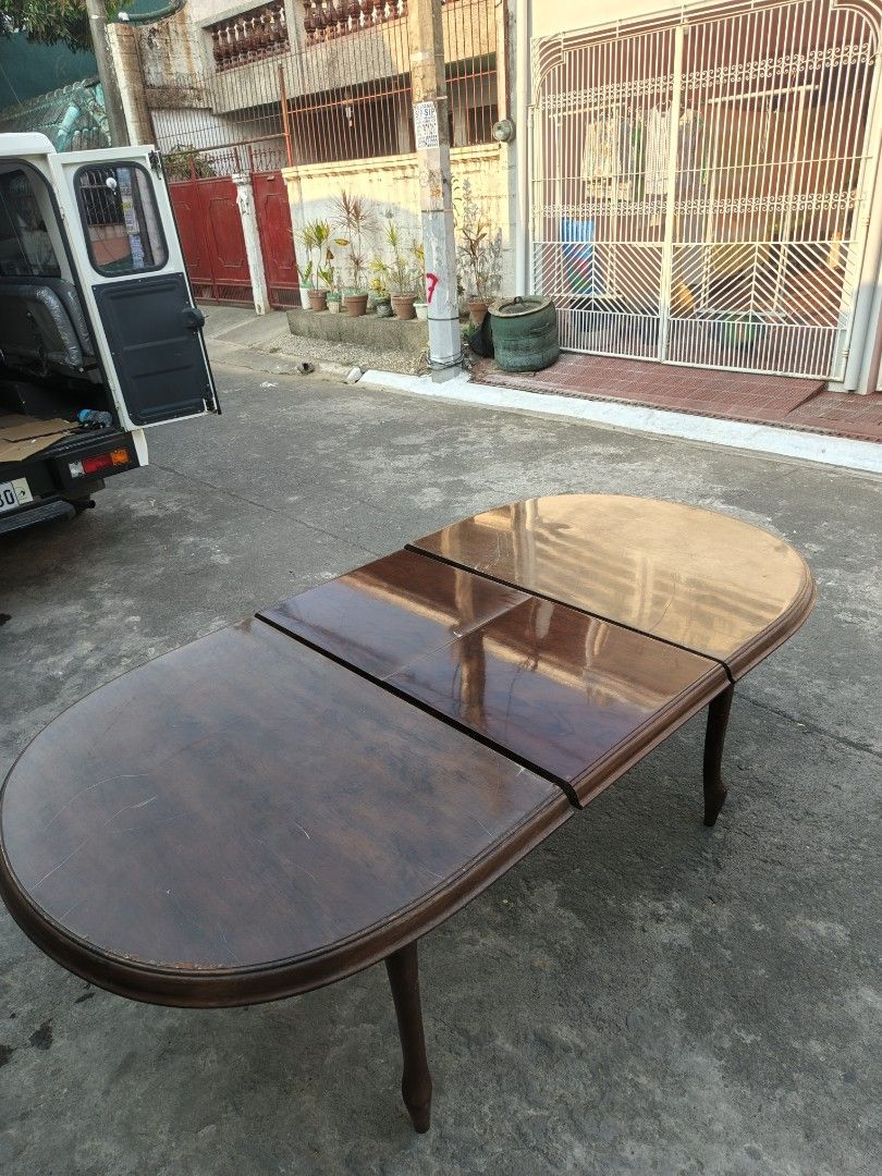 Extendable Oval Dining Table - Dark Wood (Category: Tables & Sets) located in Manila. Submitted by tonyhawk0592 (Listing ID 1445291870, Image 3). Description: - Oval dining table with extendable leaves - Dark wood finish - Seats 4-6 people comfortably - Features unique curved legs - Ideal for smaller dining areas - Minor scuffs on the surface, adding character - Ready for its new home!.