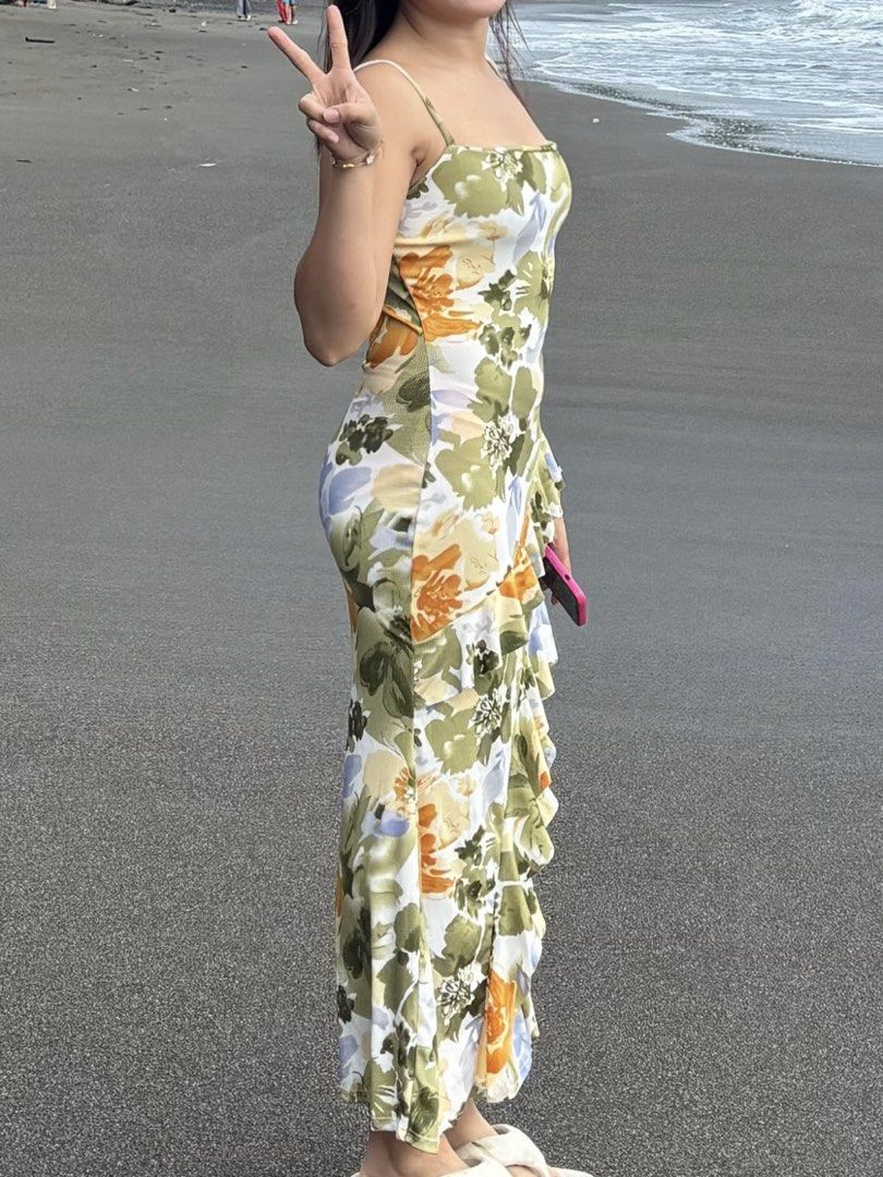 Floral Print Ruffle Maxi Dress (Category: Dresses) located in Rizal. Submitted by chezcaaphrodite (Listing ID 1445271116, Image 2). Description: - Color: Green - Size: Small to Medium - Flowy maxi dress with a vibrant floral print - Flattering silhouette with side ruffle details - Spaghetti straps for warm weather comfort - Ideal for beach days and summer parties - Easy to wear and comfortable.