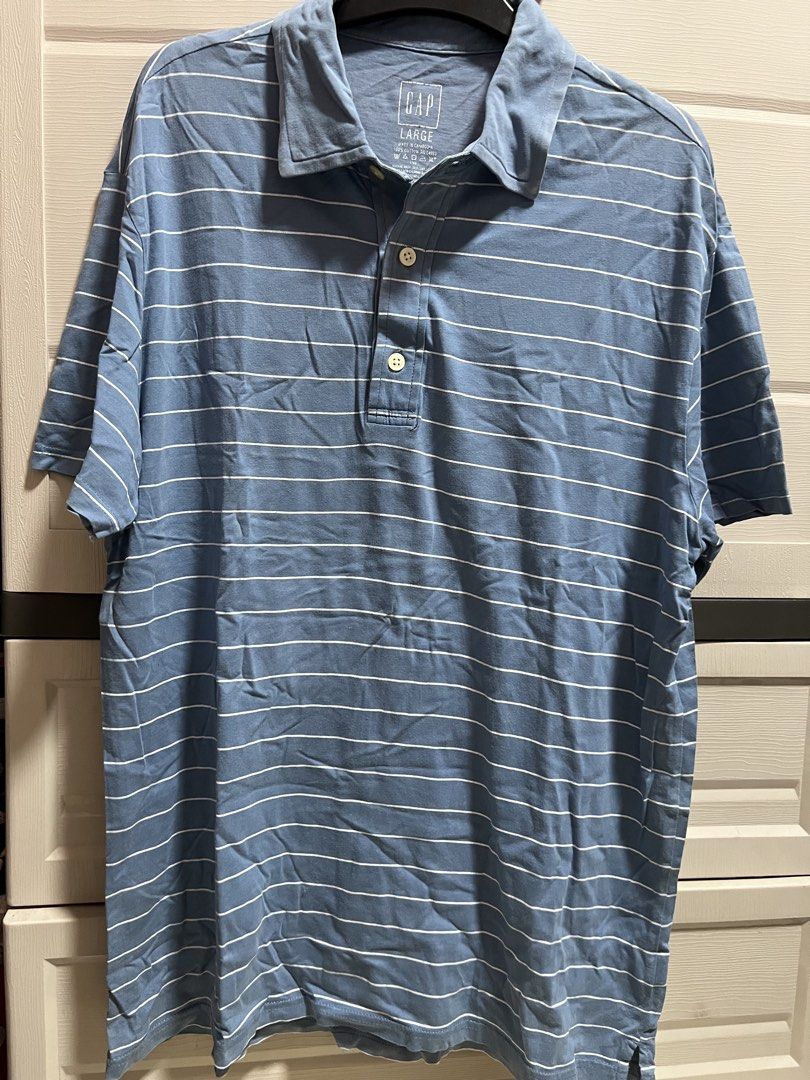GAP Blue Striped Polo Shirt - Size Large (Category: Tshirts & Polo Shirts ) located in Cainta. Submitted by p3spreloved (Listing ID 1445336678, Image 1). Description: - Classic blue polo shirt from GAP - Features thin white horizontal stripes - Short sleeves with a two-button placket - Made of 100% breathable cotton - Ideal for casual or smart-casual styling Length 30in Width 22.5in.