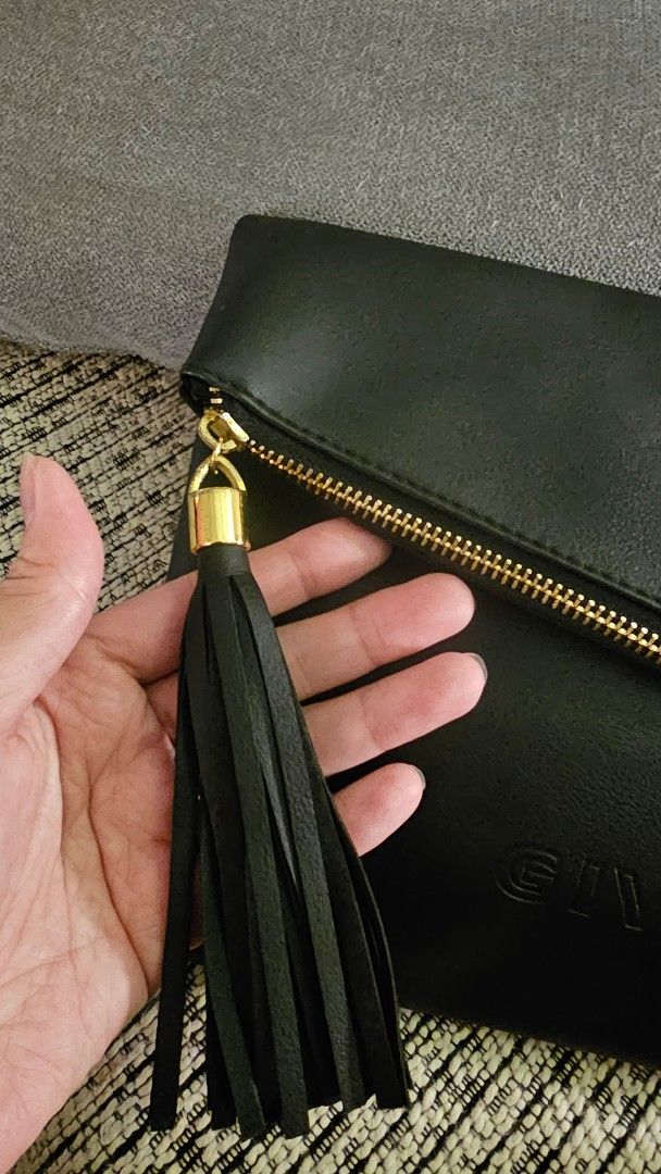 Givenchy Black 2in1 Clutch / Sling Bag (Category: Luxury Bags & Wallets) located in Makati City. Submitted by mrsdm (Listing ID 1445343753, Image 3). Description: - Givenchy black leather clutch - Iconic 4G logo embossed on one side - Brand name embossed on the other side - Secure zip closure with a stylish tassel detail - Elegant gold hardware - Ideal for evening events or as a standout accessory.