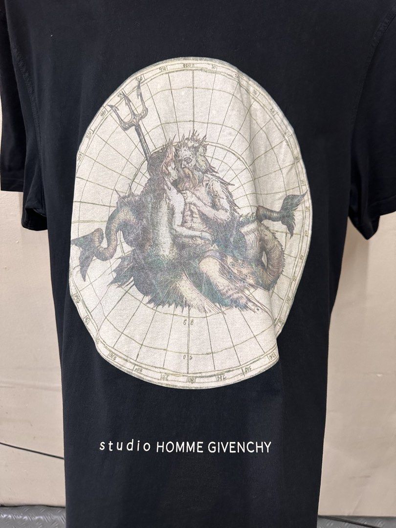 Givenchy Paris Studio Homme T-Shirt (Category: Tshirts & Polo Shirts ) located in Manila. Submitted by rashidgaddi (Listing ID 1445253529, Image 2). Description: - Black Givenchy Paris T-shirt - Features a striking Poseidon graphic print on both front and back - The graphic has a vintage, map-like aesthetic - Text below the graphic reads 'studio HOMME GIVENCHY' - A classic and iconic piece from Givenchy.