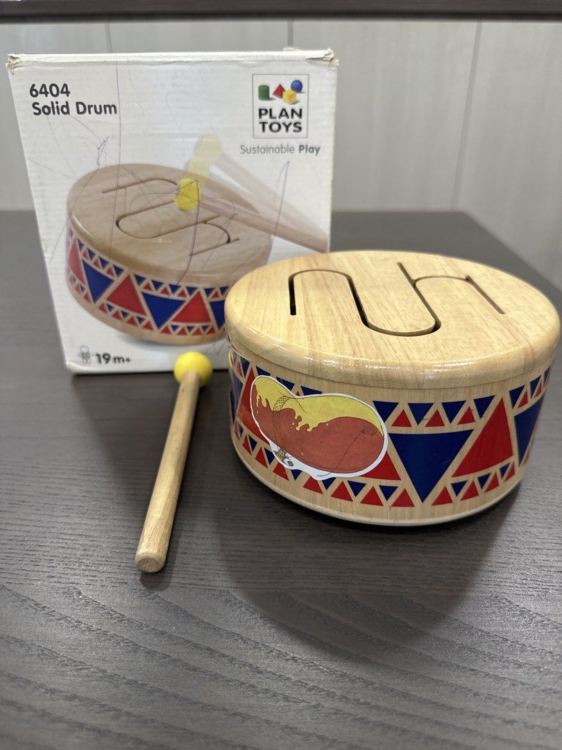 Good Condition Solid Drum (Category: Infant Playtime) located in Singapore. Submitted by sigur_ros (Listing ID 1445294257, Image 1). Description: - Solid wooden drum from Plan Toys - Includes a mallet - Features colorful geometric patterns and fun illustration - Ideal for exploring rhythm - Suitable for ages 19 months and up.