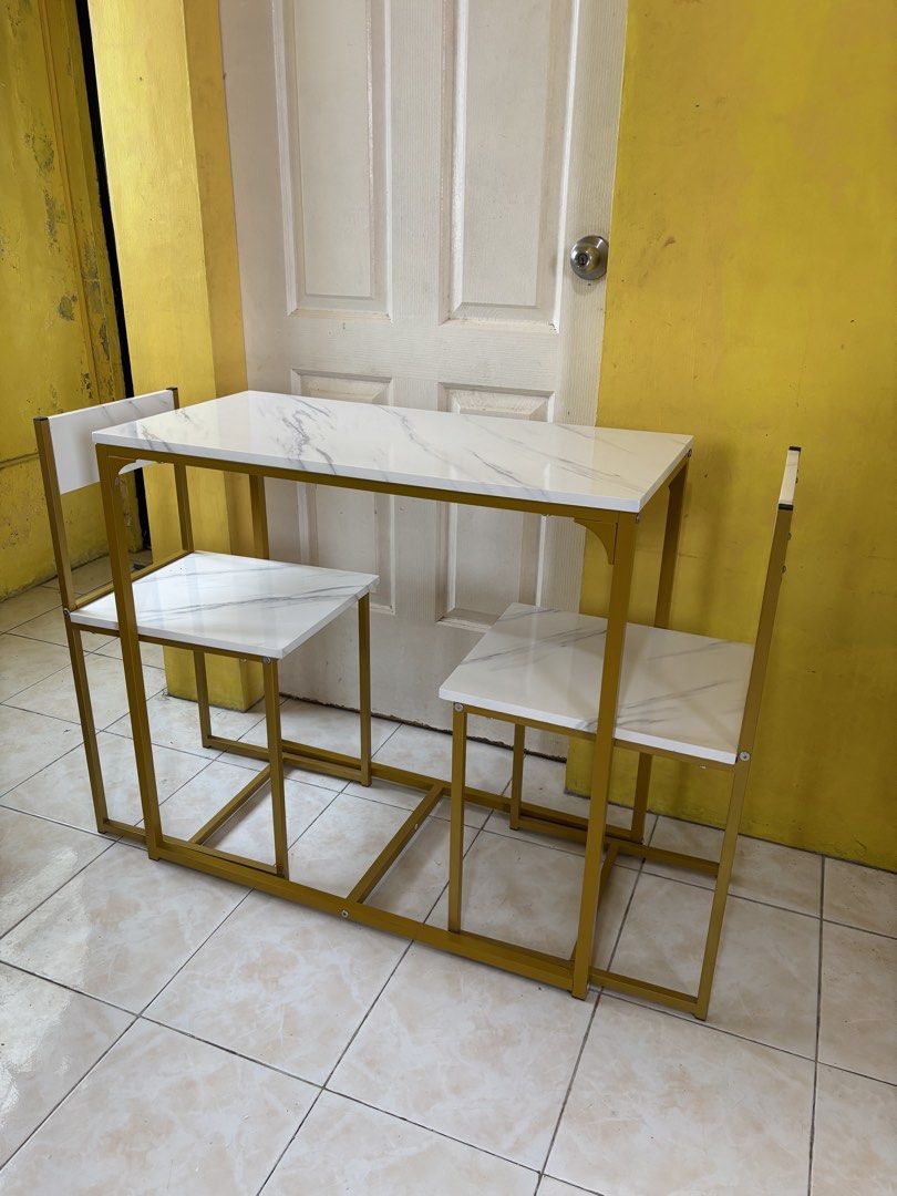 Grand Home 2-Seater Dining Table & Chair Set (Category: Tables & Sets) located in Roxas City. Submitted by jhen_c (Listing ID 1445240939, Image 2). Description: Stylish 2-seater dining set! White marble-look top, gold frame. Perfect for small spaces. Chairs tuck under. P2,800 .