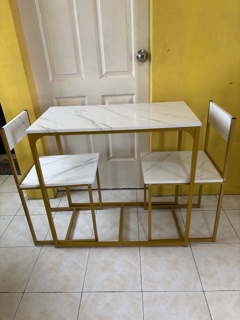 Grand Home 2-Seater Dining Table & Chair Set (Category: Tables & Sets) located in Roxas City. Submitted by jhen_c (Listing ID 1445240939, Image 1). Description: Stylish 2-seater dining set! White marble-look top, gold frame. Perfect for small spaces. Chairs tuck under. P2,800 .