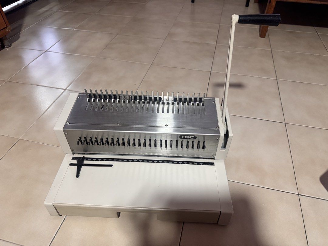 HIC Comb Binding Machine with Punching Function (Category: Craft Supplies & Tools) located in Singapore. Submitted by moneyking23 (Listing ID 1445339163, Image 1). Description: - HIC Comb Binding Machine - Punches holes and binds documents - Features a lever for easy punching - Includes a waste paper tray - Comes with a ruler guide for accurate alignment - Ideal for office or home use - Ready for its new owner.