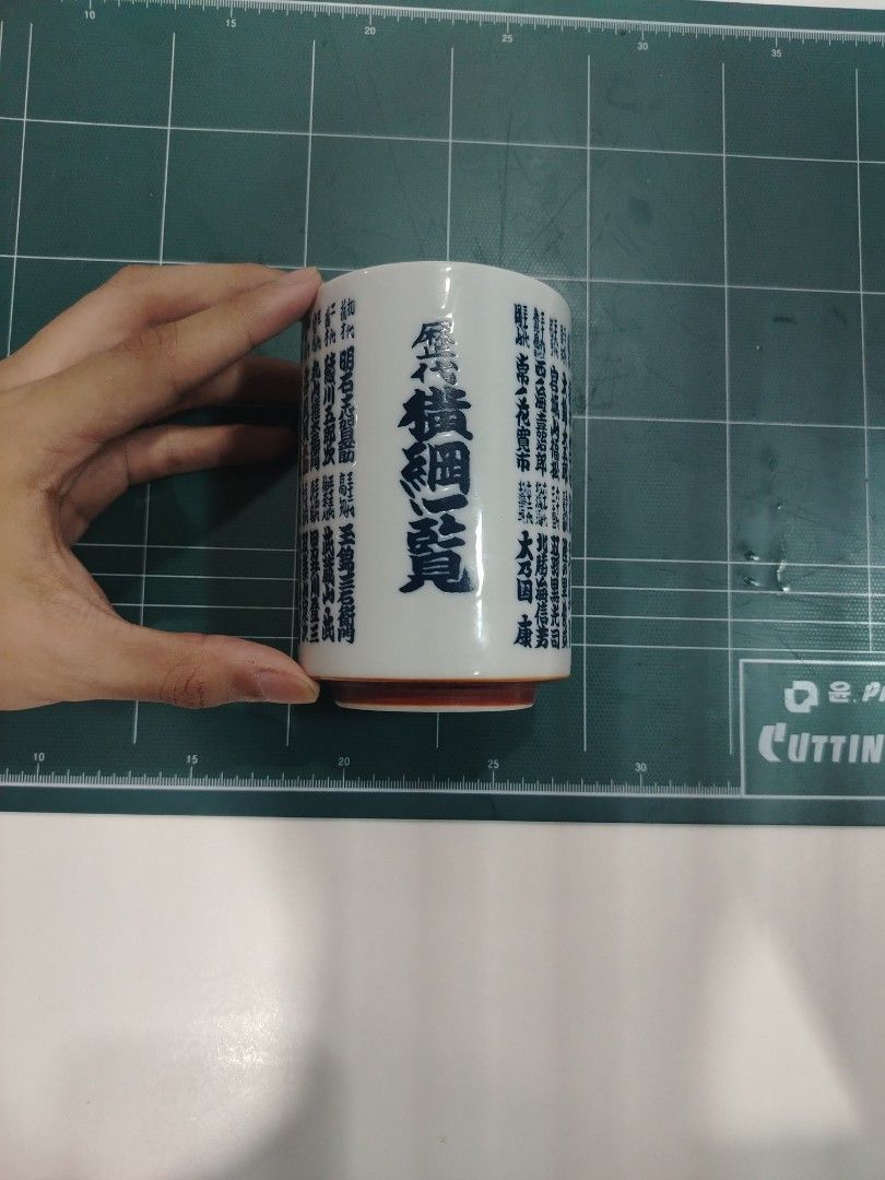 Japanese Style Ceramic Mug with Blue Calligraphy (Category: Coffee & Tea Tableware) located in Manila. Submitted by jielmabale (Listing ID 1445390853, Image 2). Description: - White ceramic mug with striking blue Japanese calligraphy all around. - Features a distinctive red base. - Ideal for enjoying your favorite tea or coffee. - Unique design, perfect for collectors or adding flair to daily use. - Measures approximately 4 inches in height. - Di