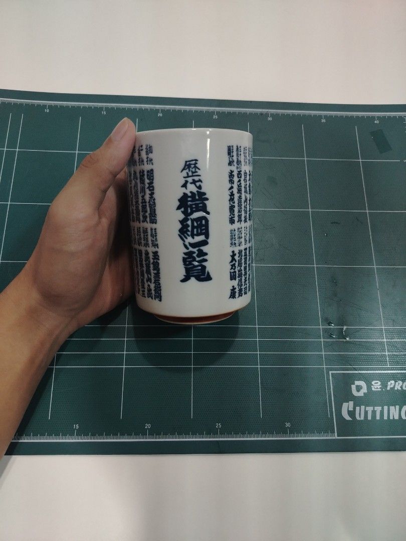 Japanese Style Ceramic Mug with Blue Calligraphy (Category: Coffee & Tea Tableware) located in Manila. Submitted by jielmabale (Listing ID 1445390853, Image 3). Description: - White ceramic mug with striking blue Japanese calligraphy all around. - Features a distinctive red base. - Ideal for enjoying your favorite tea or coffee. - Unique design, perfect for collectors or adding flair to daily use. - Measures approximately 4 inches in height. - Di