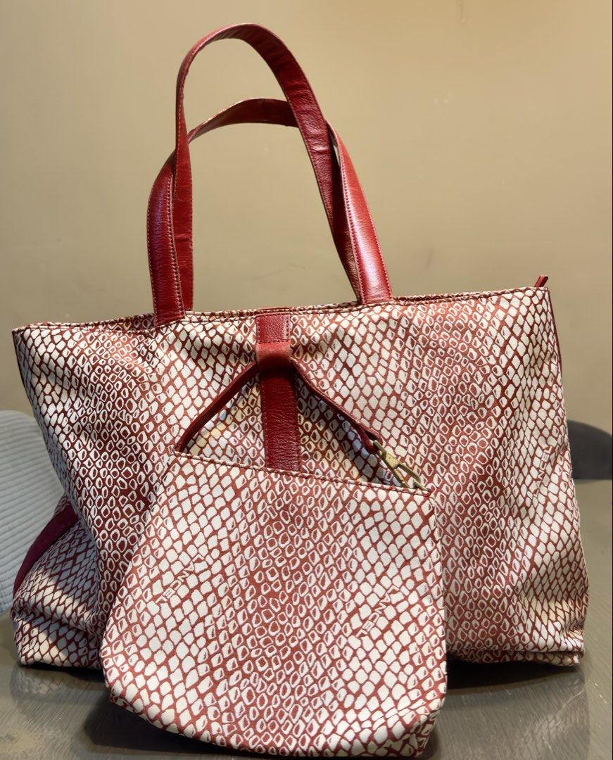 Lancel Tote Bag with Matching Pouch (Category: Luxury Bags & Wallets) located in Calamba. Submitted by doublegm (Listing ID 1445351478, Image 1). Description: - Eye-catching red and white snake print design - Genuine leather handles and trim - Interior zippered pocket for secure storage - Includes a matching pouch - Versatile for everyday errands or travel adventures.