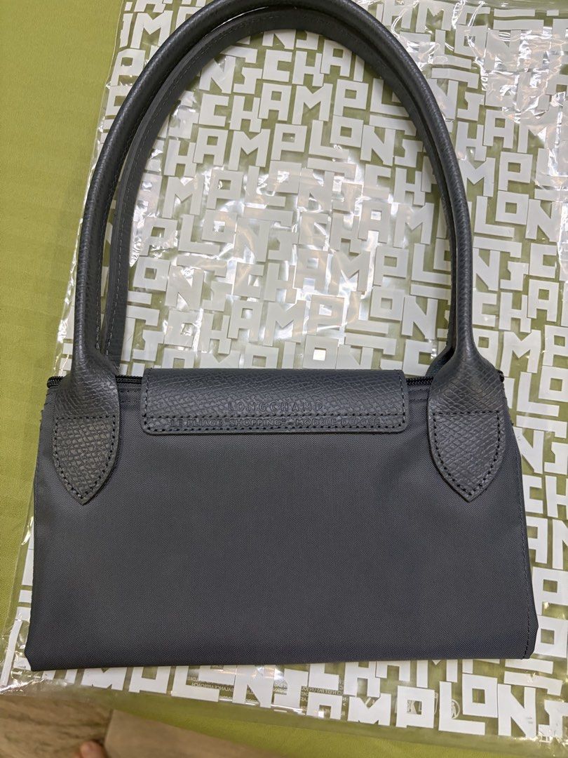 Longchamp Le Pliage Shoulder Bag Grey (Category: Luxury Bags & Wallets) located in Las Pinas. Submitted by anniea00 (Listing ID 1445387973, Image 3). Description: Brand new! Bought in Paris Comes complete - paper bag and plastic Authentic Grey Longchamp Le Pliage shoulder bag - Classic foldable design - Features leather trim and handles - Comes with original dust bag and shopping bag - Ideal for everyday use Slightly negotiable .