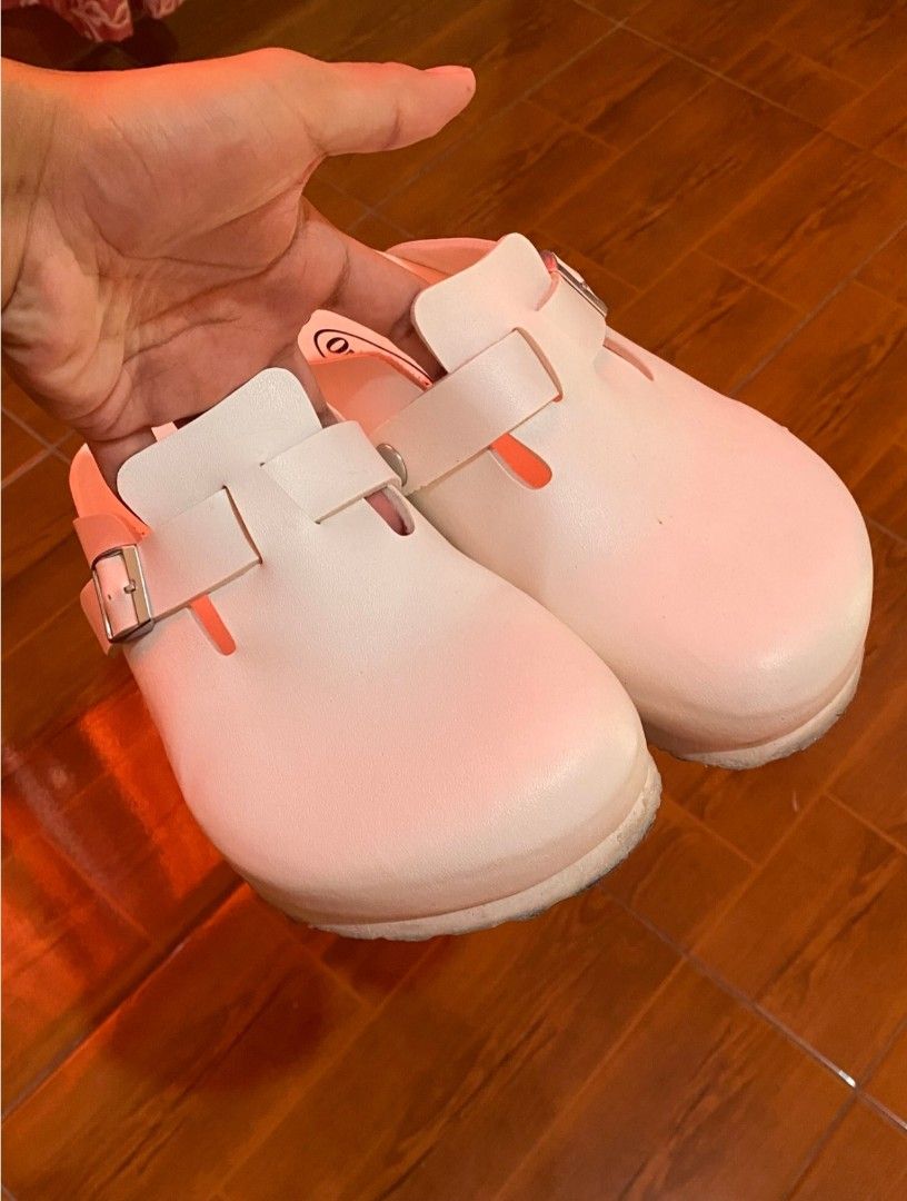 Outland Clogs Size 6 White Buckle Strap Shoes (Category: Flats & Sandals) located in Manila. Submitted by goodfrey25 (Listing ID 1445241207, Image 2). Description: - Brand: Outland - Color: White - Size: 6 - Style: Classic clog - Features: Adjustable buckle strap across the top, cork-like sole - Comfort: Easy slip-on and off - Occasion: Great for everyday wear.