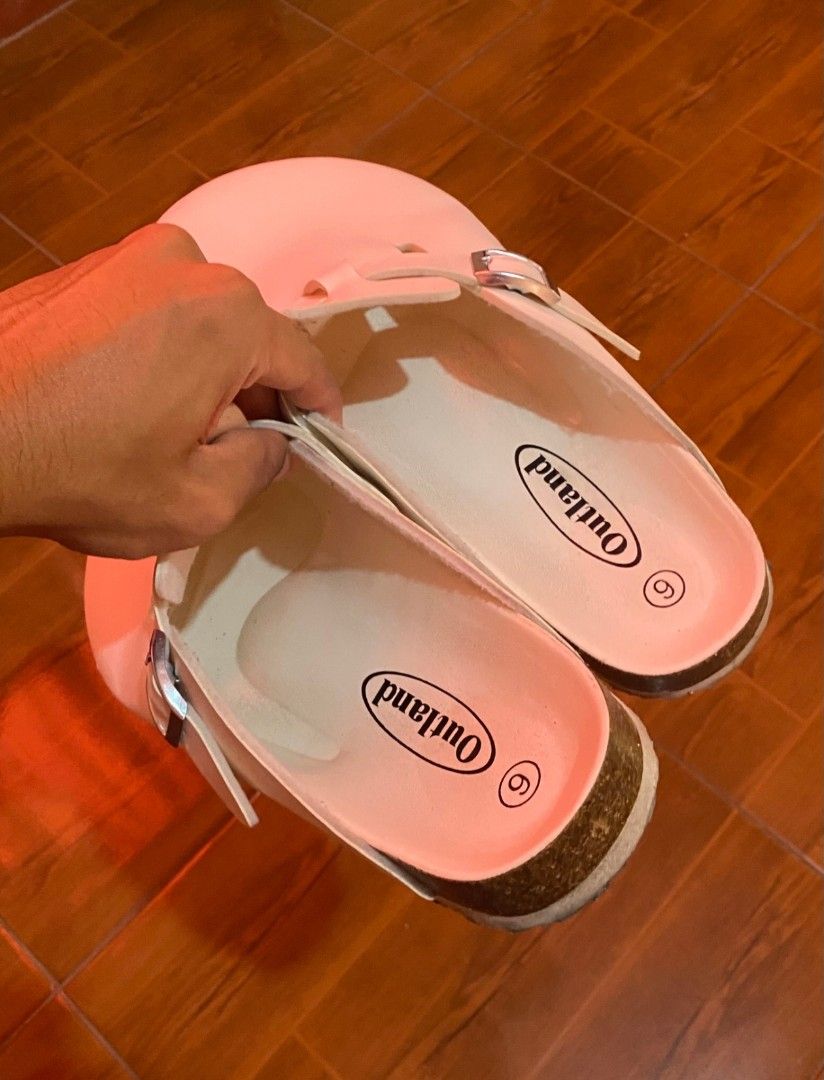 Outland Clogs Size 6 White Buckle Strap Shoes (Category: Flats & Sandals) located in Manila. Submitted by goodfrey25 (Listing ID 1445241207, Image 1). Description: - Brand: Outland - Color: White - Size: 6 - Style: Classic clog - Features: Adjustable buckle strap across the top, cork-like sole - Comfort: Easy slip-on and off - Occasion: Great for everyday wear.