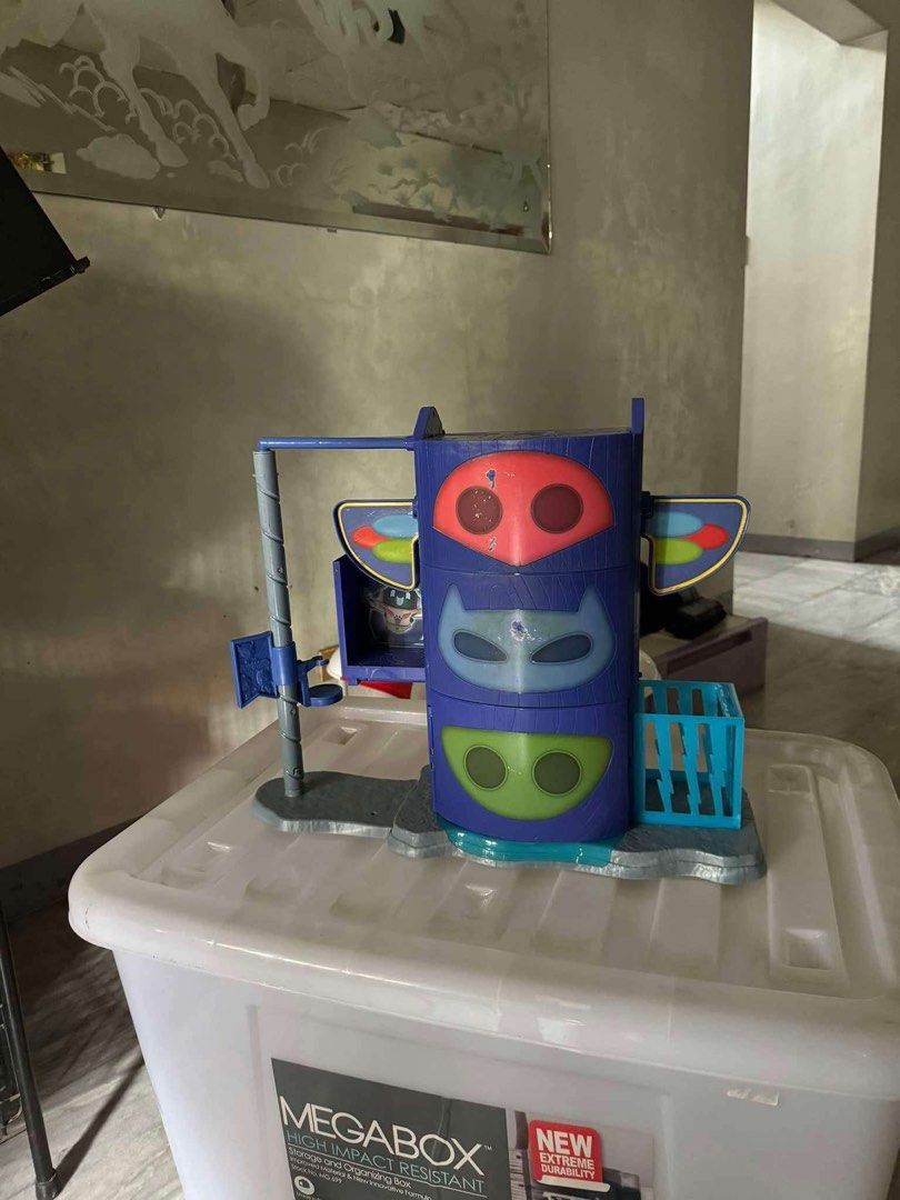 PJ Masks Headquarters Playset Toy (Category: Kids Toys) located in Quezon City. Submitted by akestrella (Listing ID 1445273981, Image 1). Description: - PJ Masks Headquarters playset - Features iconic tower with character masks - Includes launcher and small cage - Great for fans of the PJ Masks show - Minor scuffs on the red mask area.