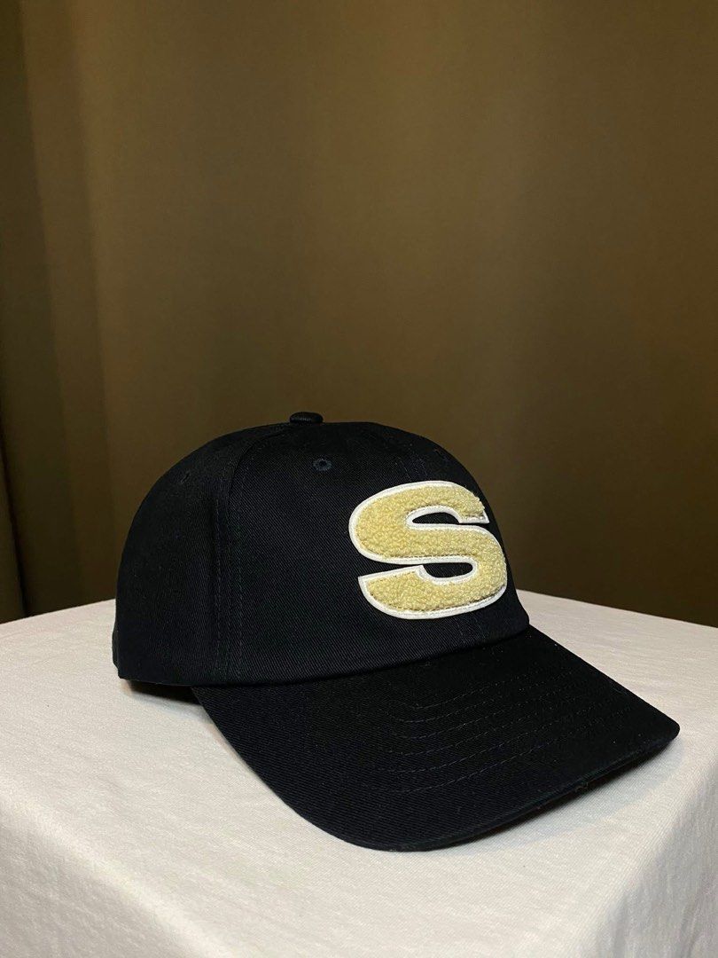 Stussy Black Cap with Gold 'S' Logo (Category: Caps & Hats) located in Tarlac. Submitted by LStuff (Listing ID 1445257995, Image 3). Description: Black baseball cap from Stussy. Features a fluffy gold 'S' logo on the front. Stussy logo embroidered on the side. Adjustable strap at the back. Great for casual wear..