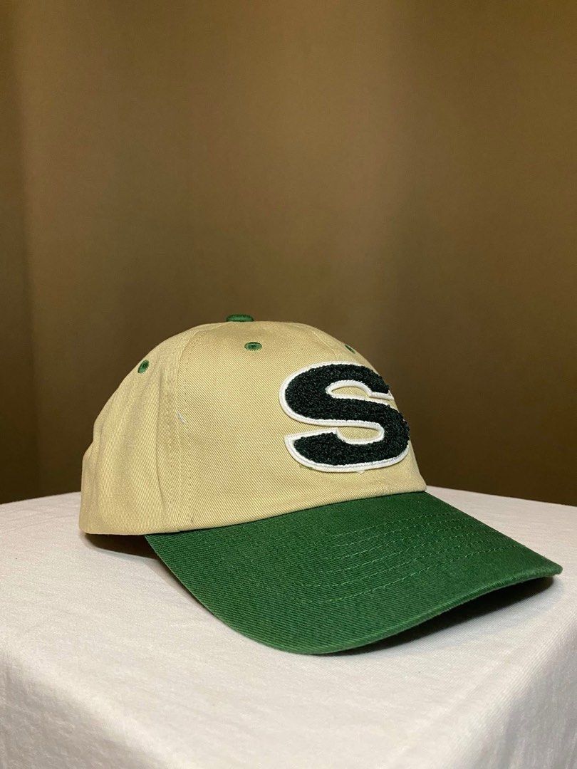 Stussy S Logo Baseball Cap Tan Green (Category: Caps & Hats) located in Tarlac. Submitted by LStuff (Listing ID 1445258076, Image 2). Description: - Tan baseball cap with a contrasting green brim. - Features a bold 'S' logo on the front. - Stussy signature embroidered on the side. - Adjustable strap at the back for a customized fit. - Perfect for everyday casual style..