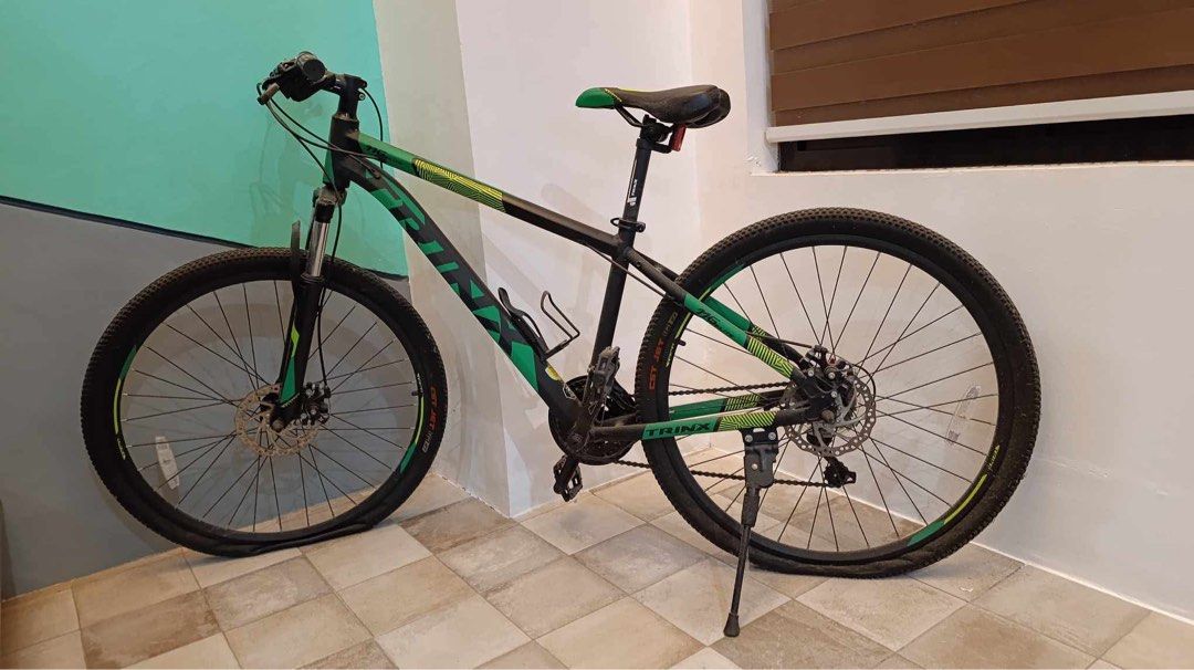 TRINX Mountain Bike (Category: Bicycles) located in Cabuyao City. Submitted by seokjinspree (Listing ID 1445378023, Image 1). Description: - TRINX Mountain Bike - Color: Black and Green frame - Brakes: Disc brakes (front and rear) - Shifters: Shimano - Tires: Flat, require pumping or replacement - Features: Kickstand included - Condition: Ready for repair and riding.