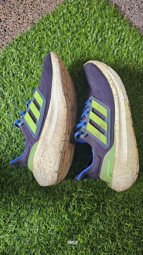 Adidas Ultraboost Running Shoes (Category: Sneakers) located in Quezon City. Submitted by geminimomma2 (Listing ID 1445430389, Image 2). Description: - Adidas Ultraboost running shoes - Color: Dark blue with green accents - Features: Boost midsole for superior comfort - Versatile: Ideal for running or casual wear - Condition: Shows some signs of wear on soles and uppers, but still has plenty of life remaining. Size: US 5.5.