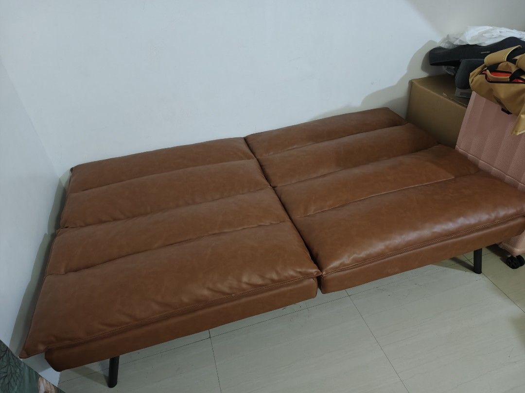 Brown Faux Leather Sofa Bed Futon (Category: Sofas) located in Manila. Submitted by cosmicrabbit-c5bc (Listing ID 1445539972, Image 3). Description: - Brown faux leather sofa bed - 2-seater design - Folds down flat for extra sleeping space - Ideal for small apartments or guest rooms - Easy-to-wipe clean material - Sturdy black metal legs - Versatile style fits most living rooms.