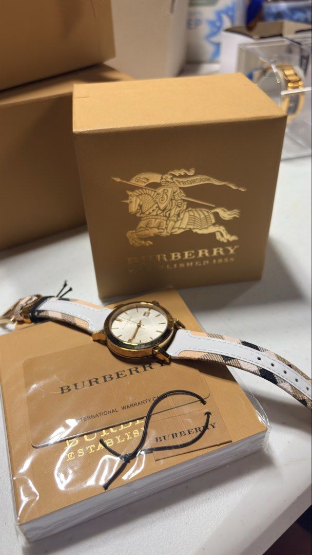 Burberry Watch (Category: Women's Watches) located in Angeles City. Submitted by sum49 (Listing ID 1445550126, Image 2). Description: BRAND: Burberry MODEL NUMBER: BU9015 CASE WIDTH: 38mm CASE COLOUR: Gold CASE MATERIAL: Stainless Steel CASE SHAPE: Circular MOVEMENT: Quartz (Battery) DIAL COLOUR: Silver STRAP MATERIAL: Leather STRAP COLOUR: White CLASP TYPE: Buckle CRYSTAL: Sapphire WATER RESISTANCE: 50 Metres - More Info PACKAGING: Official Burb