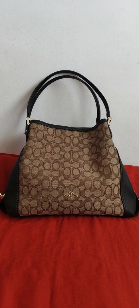 Coach Edie Signature Shoulder bag (Category: Luxury Bags & Wallets) located in Manila. Submitted by skorpiool78360 (Listing ID 1445456323, Image 1). Description: This is a Coach Edie shoulder bag 31 in signature Jacquard featuring brown leather trim. This is brand new and purchased from USA and not an ulay-ukay find..
