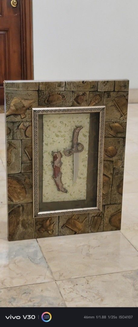 Decorative Framed Dagger Art Piece (Category: Wall Decor) located in Manila. Submitted by roblazo25 (Listing ID 1445602795, Image 3). Description: - Unique framed art piece - Features a dagger and its sheath - Frame has a textured, stone-like finish - Ideal for wall or shelf display - Adds a distinctive touch to any room -price6500.