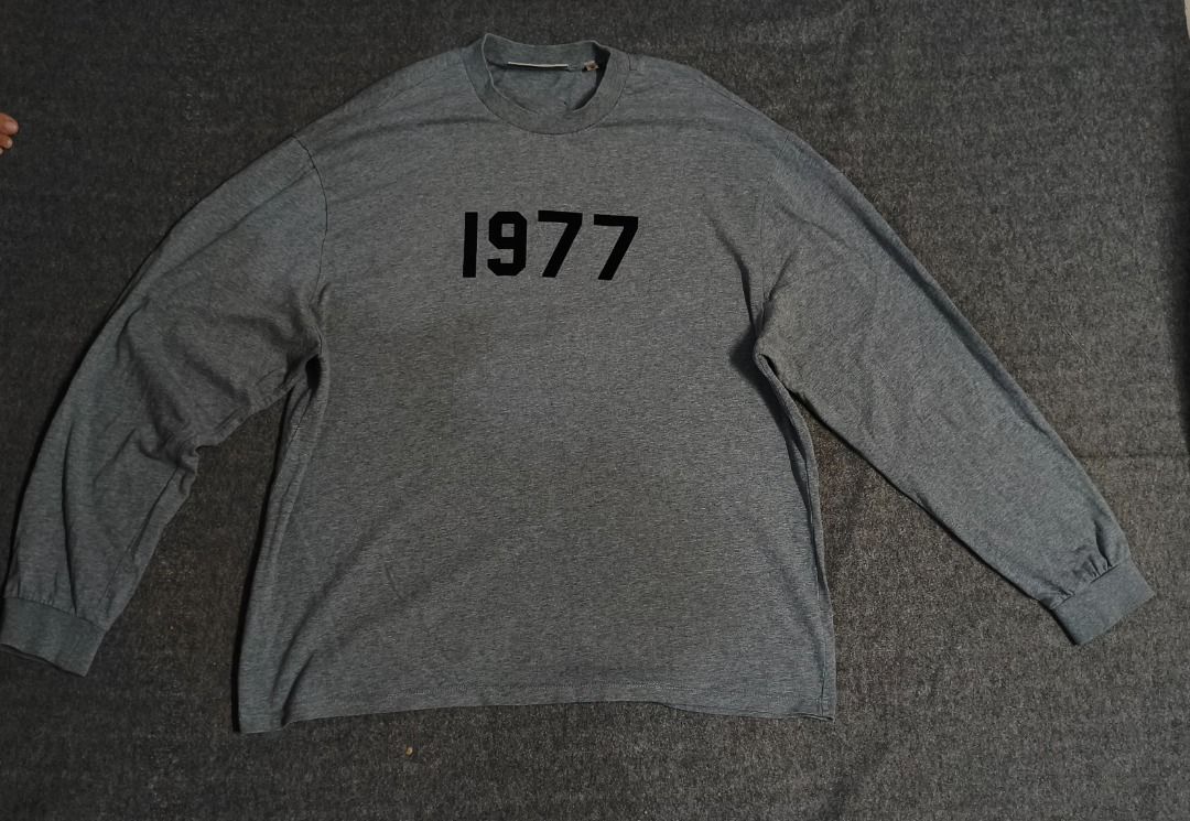 ESSENTIALS FOG '1977' Long Sleeve T-Shirt (Category: Tshirts & Polo Shirts ) located in Caloocan City. Submitted by pingpongggball (Listing ID 1443539845, Image 1). Description: - Grey long sleeve t-shirt 25x30 - Features a '1977' graphic print on the front - Classic crew neck design - Relaxed fit for comfortable casual wear - Ideal for everyday outfits.