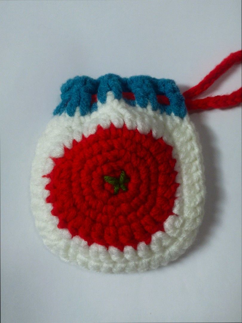 Handmade Crocheted Tomato Coin Pouch / Small Bag (Category: Purses & Pouches) located in Caloocan City. Submitted by tmaeaf (Listing ID 1445573688, Image 2). Description: - Super cute handmade crocheted pouch - Fun red, white, and blue design - Perfect for coins, small trinkets, or earbuds - Secure red drawstring closure - Compact size, fits easily in pockets or small bags - Unique and colorful accessory.