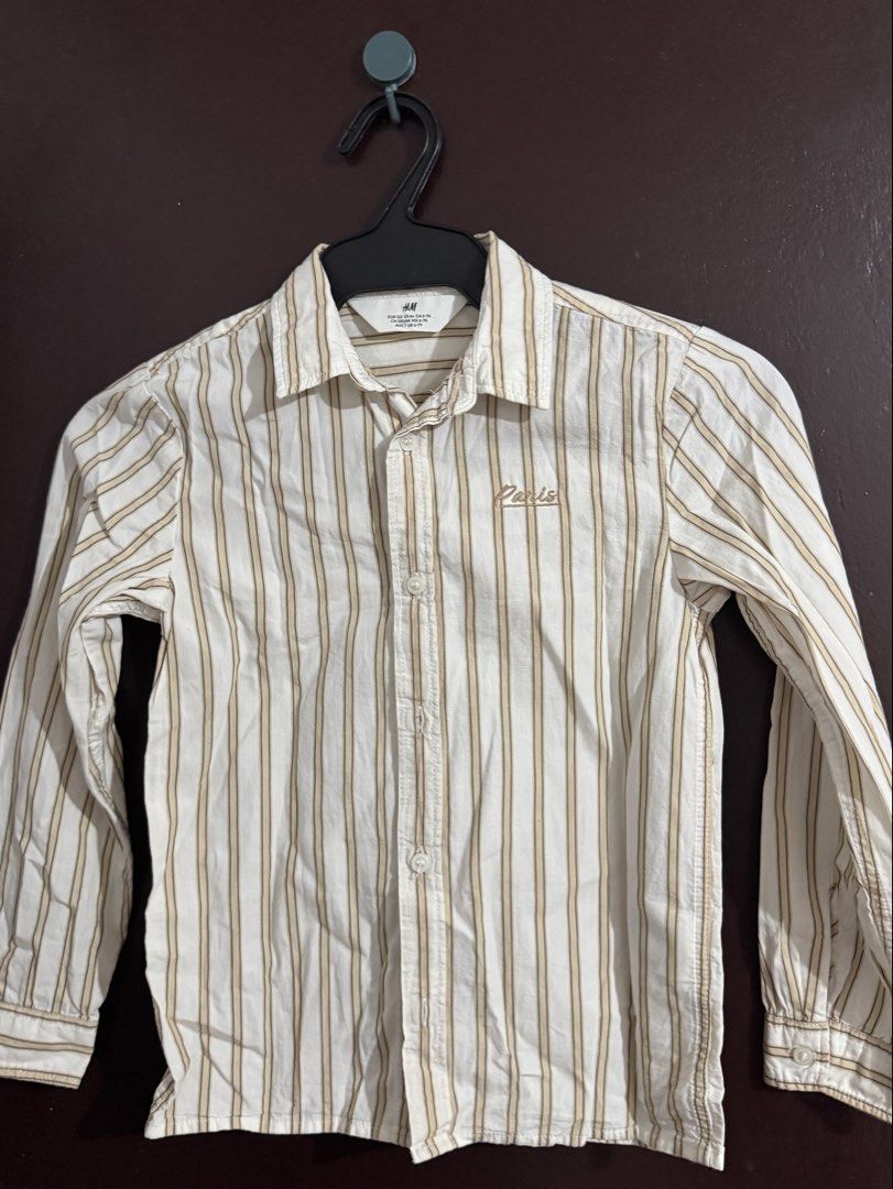H&M Striped Long Sleeve Shirt (Category: Babies & Kids Fashion) located in Cainta. Submitted by ZPeyyy (Listing ID 1445533974, Image 1). Description: - H&M white and tan striped long sleeve shirt - Small embroidered detail on the chest - Button-up front closure - Perfect for casual wear or smart casual outfits - Please check photos for detailed measurements.