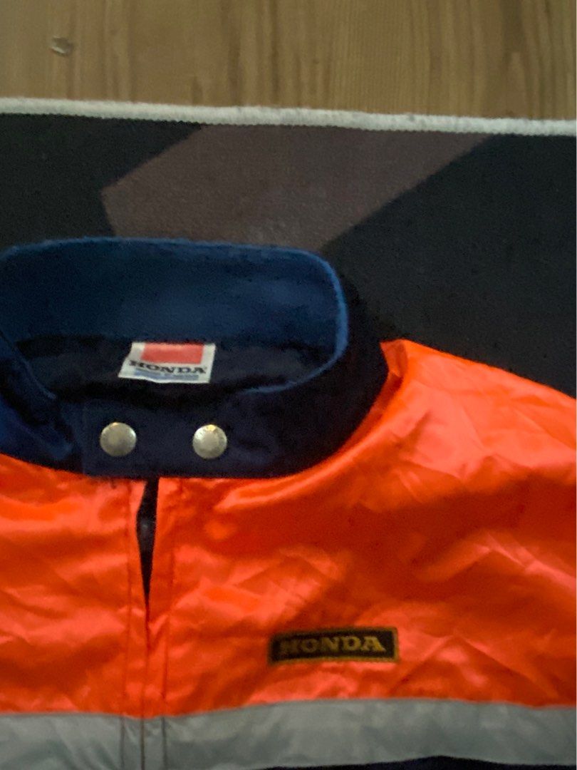 Honda Racing Jacket Orange Navy Blue (Category: Coats, Jackets and Outerwear) located in Manila. Submitted by avrilarqu43176 (Listing ID 1445592832, Image 3). Description: - Eye-catching Honda racing jacket - Vibrant orange and navy blue color scheme - Reflective silver stripes along the sides - Two convenient zippered front pockets - Official Honda logos on chest and back - Ideal for Honda enthusiasts and motorcycle lovers.