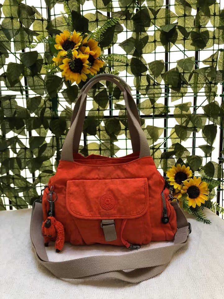 Kipling Orange Nylon Shoulder Bag with Monkey Charm (Category: Shoulder Bags) located in Davao. Submitted by 4mscllection (Listing ID 1445583531, Image 1). Description: - Vibrant orange Kipling bag - Made from durable nylon material - Convenient front pocket with drawstring closure - Includes a detachable shoulder strap for versatile carrying - Comes with the iconic Kipling monkey charm - All zippers are in excellent working condition - Ideal for