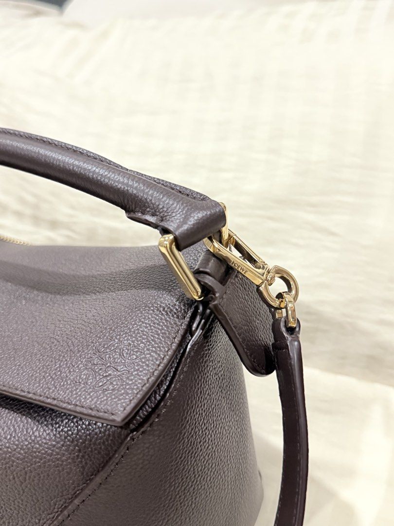 Loewe Puzzle Bag (Category: Luxury Bags & Wallets) located in Dasmarinas. Submitted by joyrazon (Listing ID 1445565435, Image 3). Description: - Authentic Loewe Puzzle Bag - Color: Dark Brown - Material: Pebbled Leather - Hardware: Gold - Carrying Options: Top Handle or Shoulder Strap - Closure: Side Zipper - Design: Classic Origami-inspired.