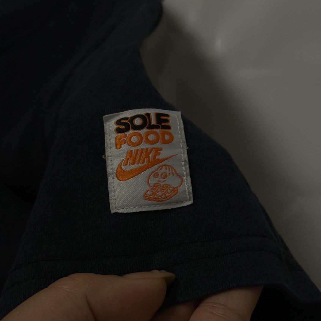 Nike "Served Fresh" Graphic T-Shirt (Category: Tshirts & Polo Shirts ) located in Manila. Submitted by johnedel_james (Listing ID 1445564500, Image 3). Description: - Black Nike T-shirt - Size: 2XL - Features orange "Served Fresh" graphic with a cute cartoon character in sneakers - "Sole Food Nike" tag on sleeve - Material: 100% Cotton - Ideal for casual wear.