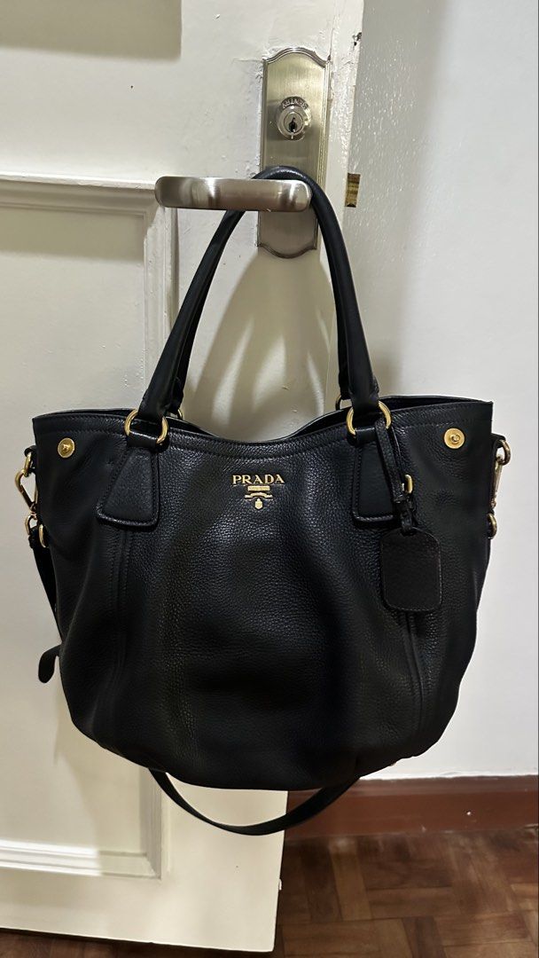 Prada Black Leather Tote Bag (Category: Luxury Bags & Wallets) located in Makati City. Submitted by janeabat (Listing ID 1445493508, Image 1). Description: Prelove Authentic Prada bag - Black pebbled leather - Gold hardware details - Top handles - Detachable shoulder strap - Includes leather luggage tag - Spacious interior - Ideal for daily use or travel - Classic Prada piece.