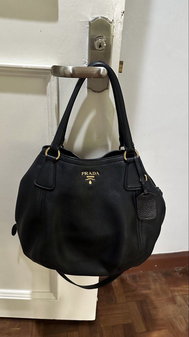 Prada Black Leather Tote Bag (Category: Luxury Bags & Wallets) located in Makati City. Submitted by janeabat (Listing ID 1445493508, Image 3). Description: Prelove Authentic Prada bag - Black pebbled leather - Gold hardware details - Top handles - Detachable shoulder strap - Includes leather luggage tag - Spacious interior - Ideal for daily use or travel - Classic Prada piece.