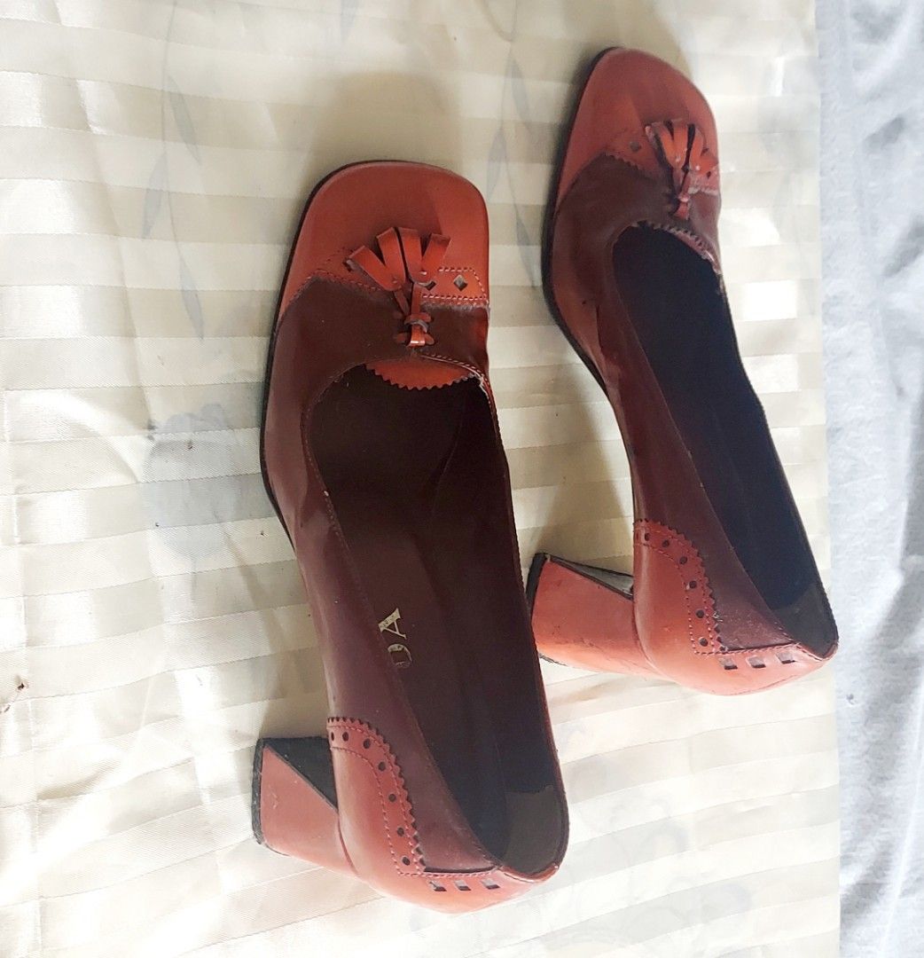 Prada Leather Tassel Block Heels Size 37.5 (Category: Heels) located in Cavite. Submitted by bonita2230 (Listing ID 1445469465, Image 2). Description: - Brand: Prada - Color: Rich Brown & Orange Leather - Design: Square toe with tassel detail - Heel: Stacked block heel - Accents: Wingtip detailing on sides - Origin: Made in Italy - Size: 37.5.