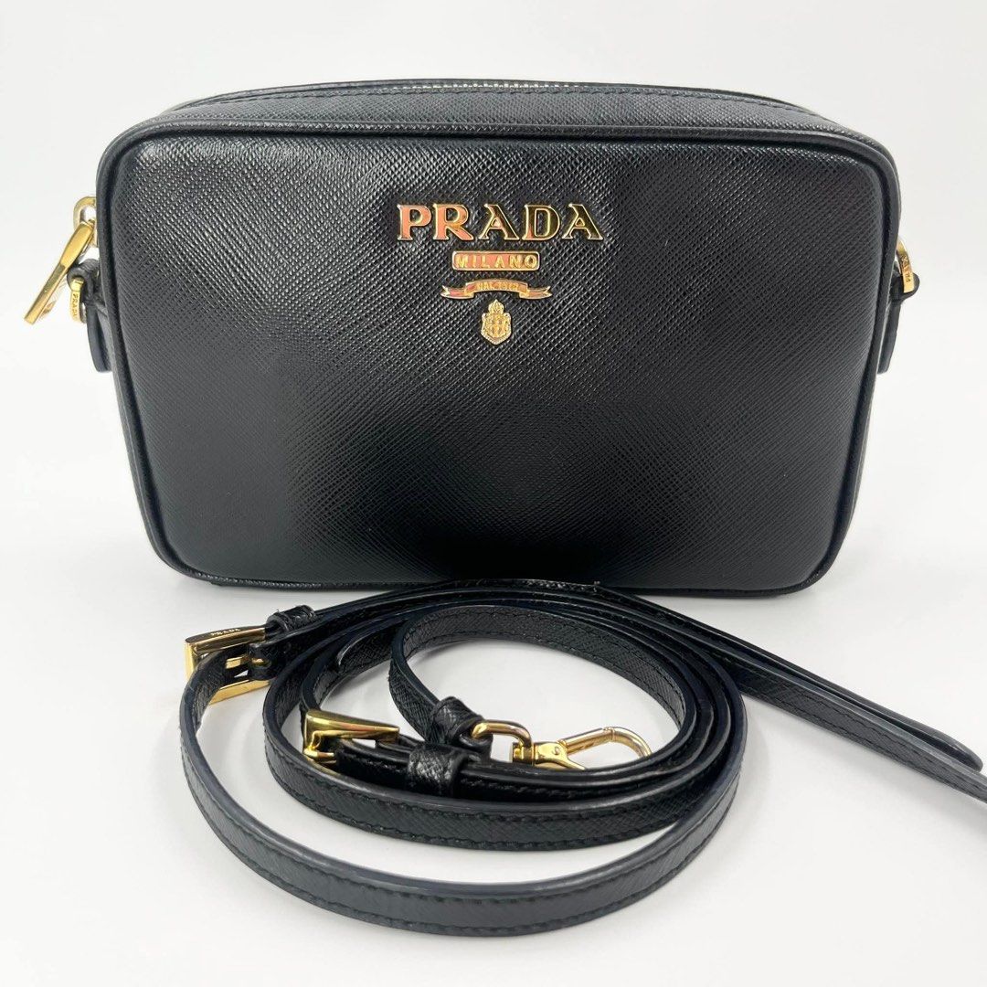 Prada Saffiano Leather Camera Bag Black Gold Hardware (Category: Luxury Bags & Wallets) located in Manila. Submitted by missgrace_collection (Listing ID 1445513424, Image 1). Description: - Classic black Prada camera bag - Genuine Saffiano leather - Elegant gold hardware details - Adjustable strap for comfort - Spacious enough for phone and essentials - Versatile for everyday or evening use - Immaculate interior condition - Approximate dimensions