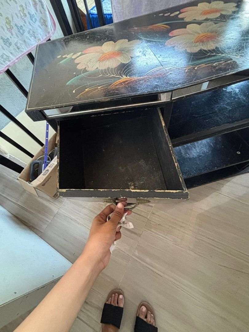 Preloved Solid Wood Entertainment TV Stand with Storage Cabinet ✨ (Category: Shelves, Cabinets & Racks) located in Lubao. Submitted by lelayph (Listing ID 1445432434, Image 3). Description: This is a solid wooden TV console/entertainment cabinet with a center drawer, open shelves, and two side storage cabinets. It is ideal for a TV, sound system, books, decorations, Wi-Fi router, or other household items. The hand-painted floral design gives it a