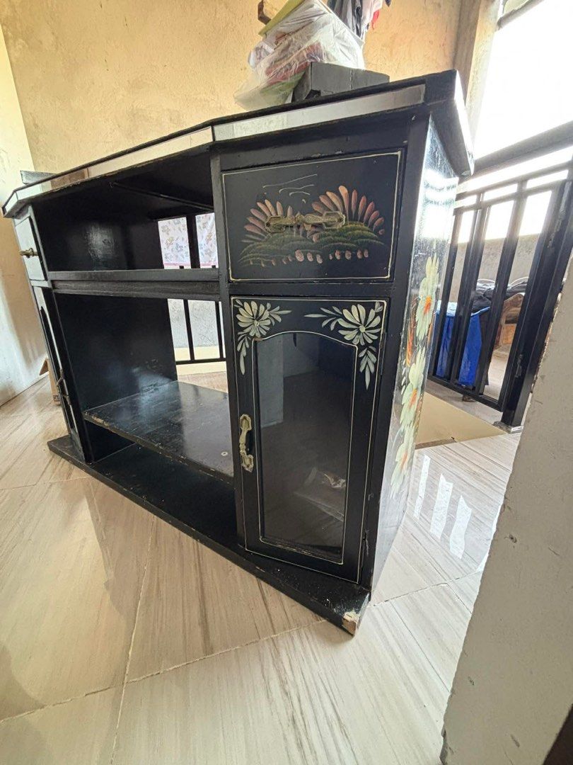 Preloved Solid Wood Entertainment TV Stand with Storage Cabinet ✨ (Category: Shelves, Cabinets & Racks) located in Lubao. Submitted by lelayph (Listing ID 1445432434, Image 2). Description: This is a solid wooden TV console/entertainment cabinet with a center drawer, open shelves, and two side storage cabinets. It is ideal for a TV, sound system, books, decorations, Wi-Fi router, or other household items. The hand-painted floral design gives it a