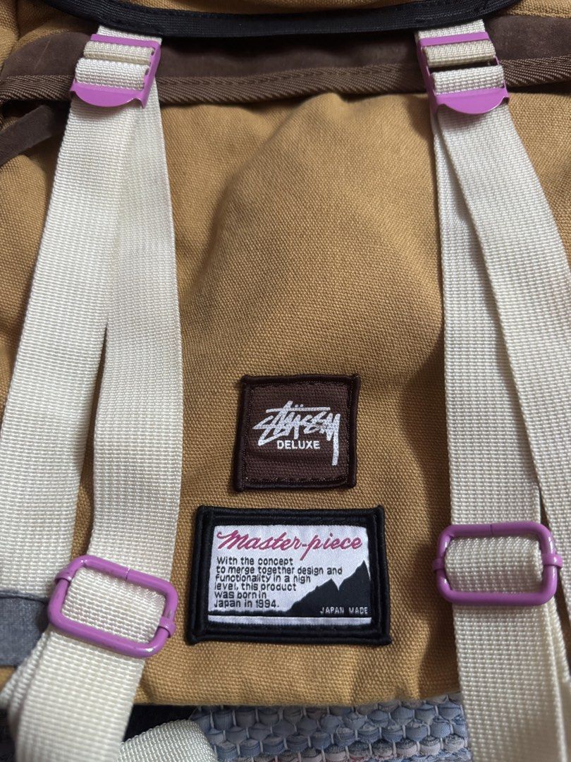 Stussy x Deluxe Master-piece Backpack Tan (Category: Backpacks) located in Makati City. Submitted by vinsanity41546 (Listing ID 1445587409, Image 2). Description: - Tan canvas backpack - Brown suede accents - Stussy Deluxe x Master-piece collaboration - Adjustable straps with purple buckles - Side zip pocket - Ideal for everyday use or travel.