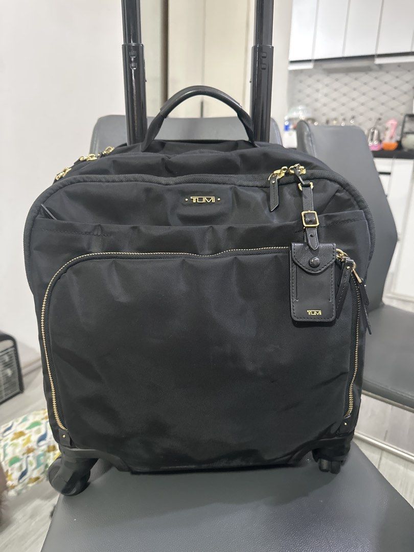 Tumi Black Nylon Rolling Carry-On Trolley Bag (Category: Luggage) located in Cainta. Submitted by shopbyyna (Listing ID 1445513544, Image 1). Description: - Stylish black Tumi trolley bag - Made from durable nylon with elegant gold hardware - Multiple interior compartments for excellent organization - Features a retractable handle and smooth-rolling wheels for effortless transport - Ideal for both leisure travel and business trips - Offers ample 