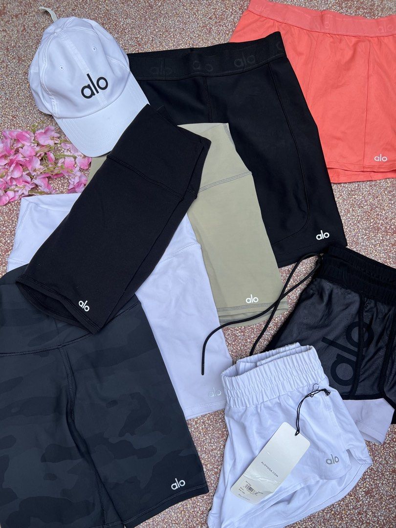 Alo cyclings shorts (Category: Activewear) located in Taguig. Submitted by sbmanilaaa (Listing ID 1445792438, Image 1). Description: - Bundle includes Alo Yoga athletic wear. - Comes with a white baseball cap featuring the Alo logo. - Includes multiple pairs of shorts in various colors: black, camouflage, white, tan, and coral. - Shorts styles include both biker shorts and looser athletic shorts. - Versatile for workouts or casual everyday wear. 