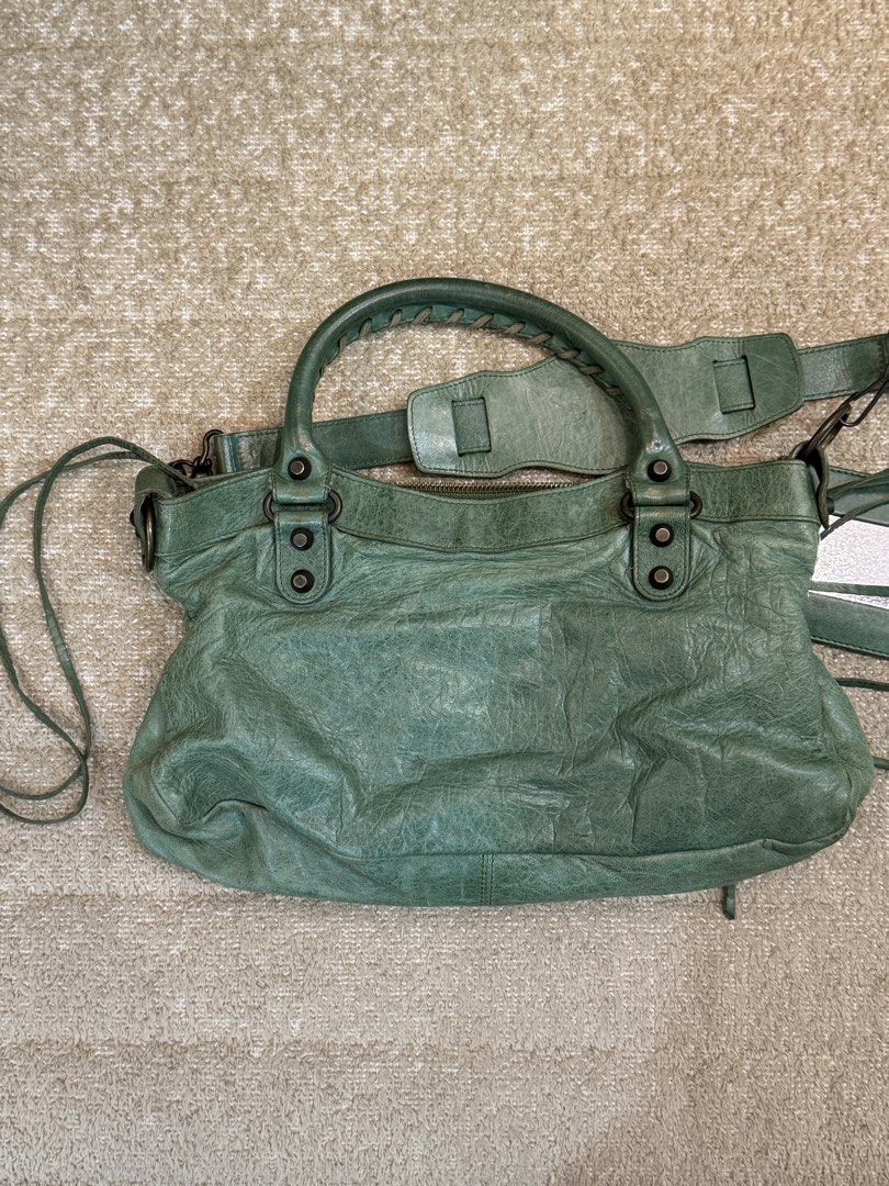 Balenciaga First Green (Category: Luxury Bags & Wallets) located in Manila. Submitted by shopelisse (Listing ID 1445740026, Image 3). Description: - Authentic Green Balenciaga City Bag - Made from soft, genuine leather - Dual top handles - Detachable shoulder strap for versatile carrying - Signature mirror tag included - Secure top zipper closure - Interior lined with black fabric - Please note: Shows some signs of wear on the leather and hardwar