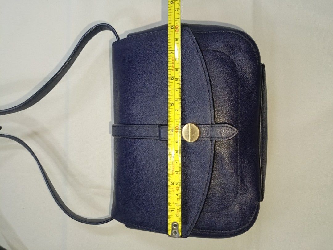 Beanpole Blue Leather Sling Bag (1) (Category: Luxury Bags & Wallets) located in San Pedro. Submitted by elevens_online_thrift_shop (Listing ID 1445762182, Image 2). Description: 📍Brand * **Beanpole:** This is a well-known South Korean premium fashion brand owned by Samsung C&T Fashion Group. The branding is explicitly visible on the gold-tone metal button on the front strap closure , the internal fabric tag , and woven into the interior lining 
