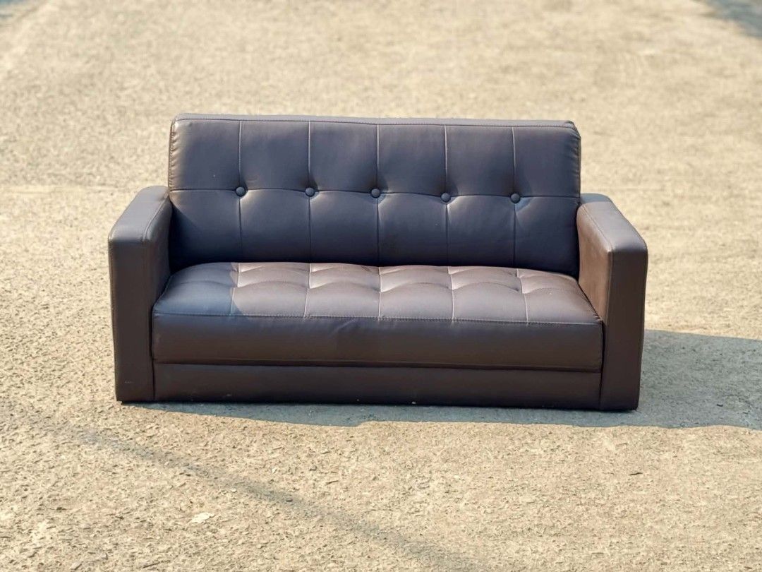 Brown Tufted Faux Leather 2-Seater Sofa (Category: Sofas) located in Valenzuela. Submitted by upcycle_things (Listing ID 1445688980, Image 1). Description: - Brown faux leather sofa - Tufted backrest and seat cushions - Comfortably seats two people - Ideal for small living rooms or apartments - Ready for a new home.