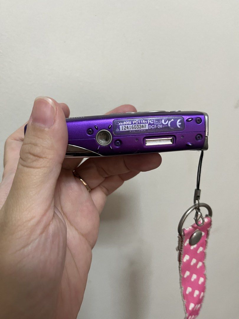 Canon Digital IXUS 50 Purple Digital Camera (Category: Cameras) located in Paranaque City. Submitted by trishalmgo (Listing ID 1445640389, Image 3). Description: - Purple Canon Digital IXUS 50 compact digital camera - Includes pink and white heart strap - Minor scuffs on body (age-appropriate) - Screen has some dust - Fun and easy to use - Super vintage (I’m the original owner. I used this when I was in college. 😅) - No charger - Because I lost 