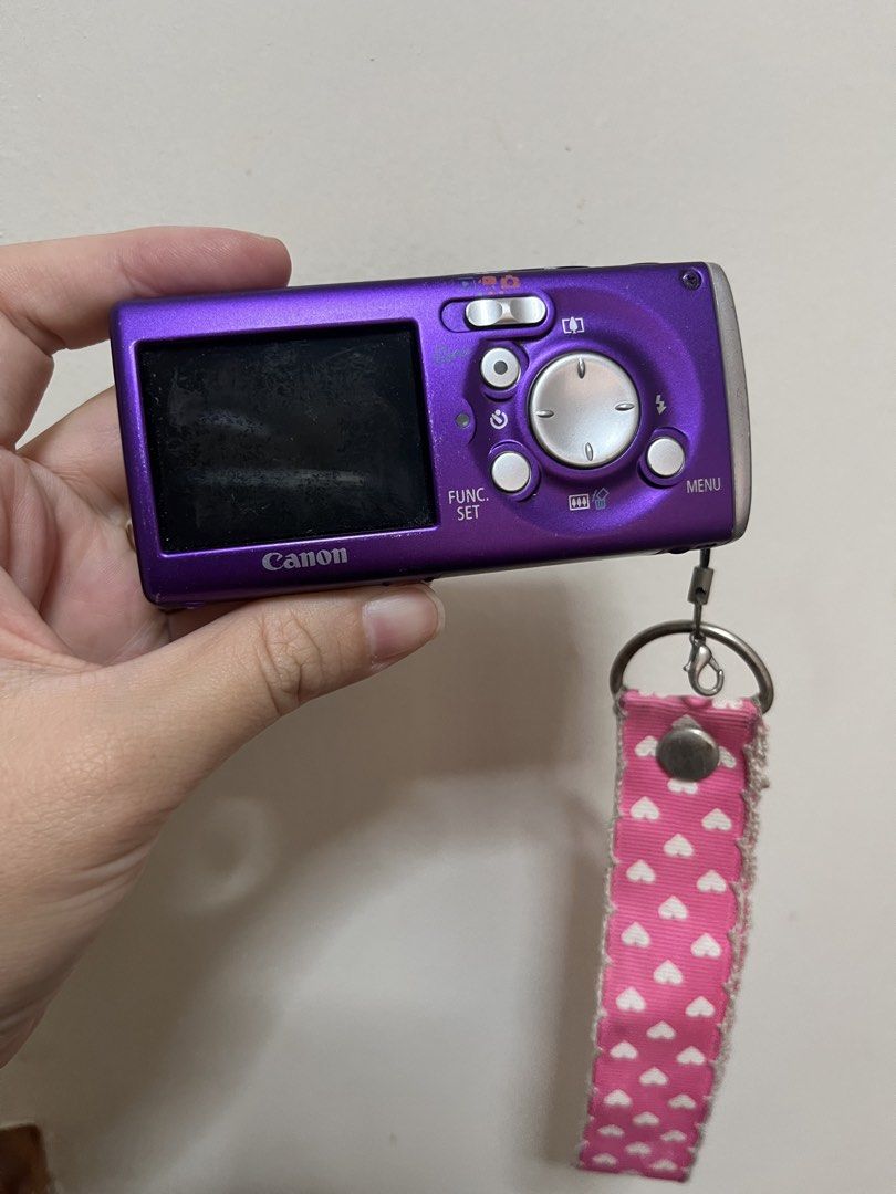 Canon Digital IXUS 50 Purple Digital Camera (Category: Cameras) located in Paranaque City. Submitted by trishalmgo (Listing ID 1445640389, Image 2). Description: - Purple Canon Digital IXUS 50 compact digital camera - Includes pink and white heart strap - Minor scuffs on body (age-appropriate) - Screen has some dust - Fun and easy to use - Super vintage (I’m the original owner. I used this when I was in college. 😅) - No charger - Because I lost 