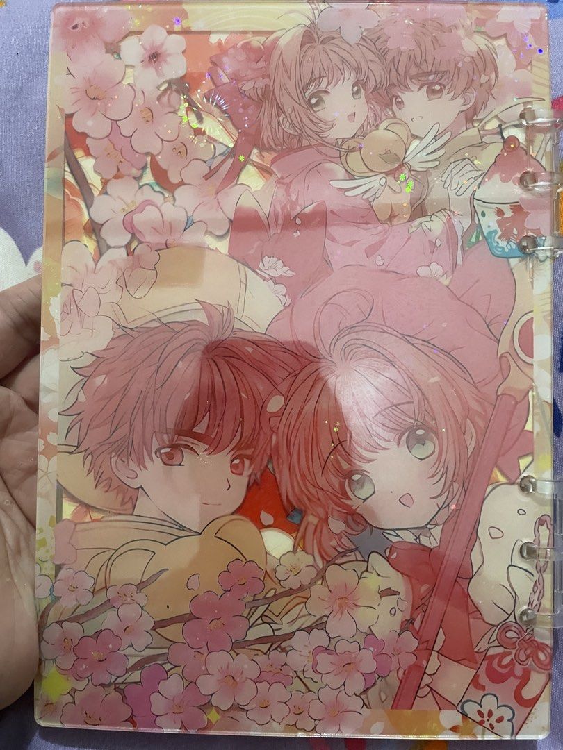 Cardcaptor Sakura Shaker Binder Notebook (Category: Stationery & School Supplies) located in Manila. Submitted by elayncy (Listing ID 1445792200, Image 2). Description: - Cute binder notebook featuring Cardcaptor Sakura characters. - Lovely cherry blossom design on the cover. - 3D effect cover with glitter and small charms inside. - Perfect for fans of the anime. - Great for journaling or taking notes. WITH MINIMAL FLAW Damaged during shipment.