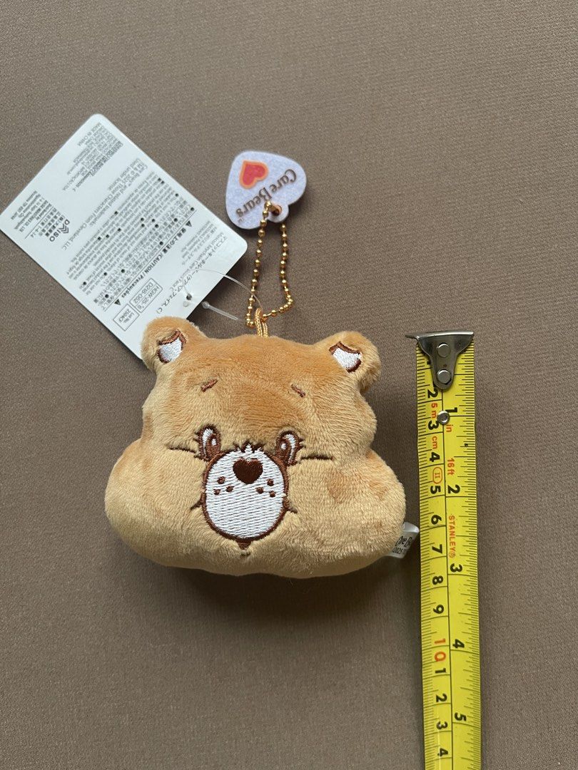 Care Bears Brown Bear Plush Keychain with Tag (Category: Plushies & Soft Toys) located in Manila. Submitted by shopandscore (Listing ID 1445687873, Image 2). Description: - Adorable brown bear plush keychain - Features official Care Bears branding - Brand new with original tag attached - Ideal accessory for bags or keys - Small and portable design.