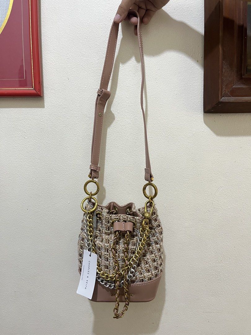 Charles & Keith Tweed Bucket Bag with Chain Strap (Category: Cross-body Bags) located in Manila. Submitted by xenna31 (Listing ID 1445764543, Image 2). Description: - Cute bucket bag from Charles & Keith - Tweed body with faux leather trim - Mix of gold and silver chain straps - Drawstring closure - Brand new with original tag attached - Ideal for casual outings.