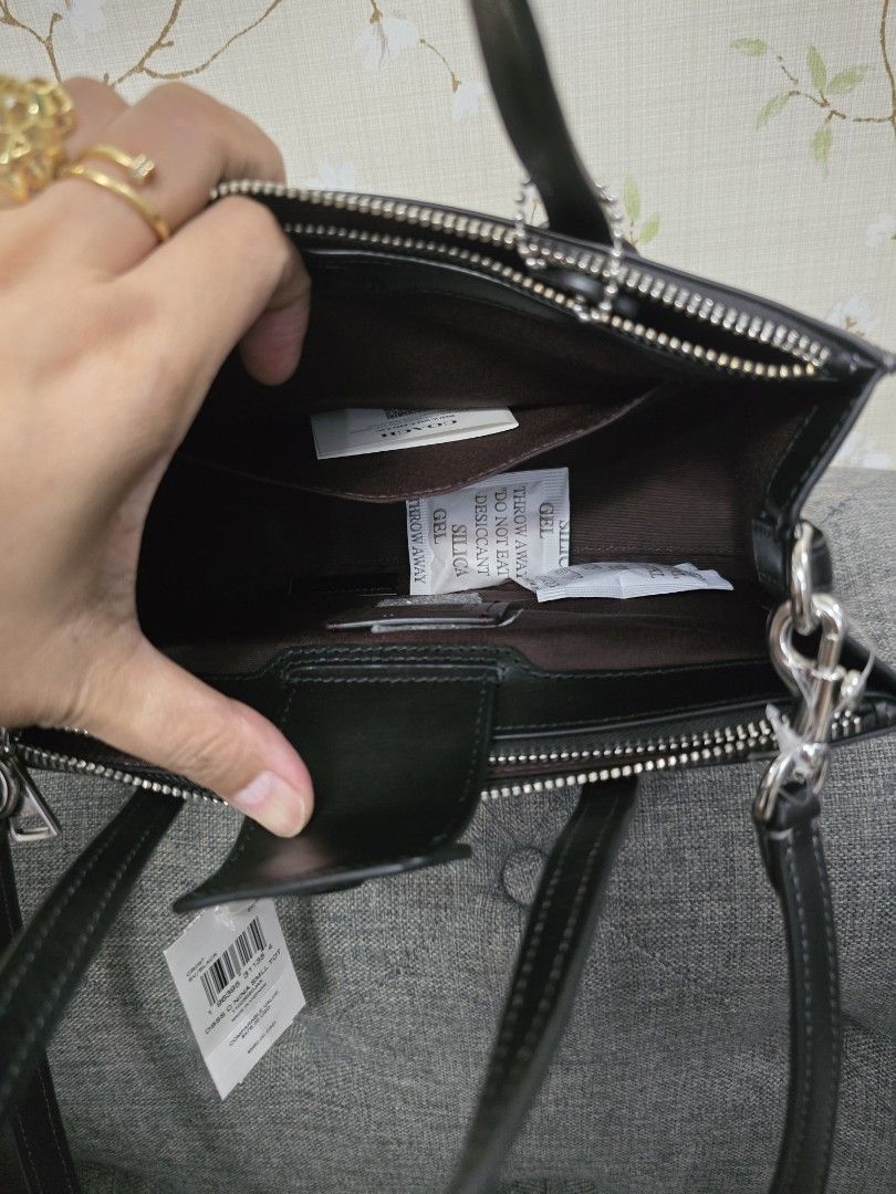 Coach Nina Mini (Category: Luxury Bags & Wallets) located in Quezon City. Submitted by iammjdlb (Listing ID 1445747440, Image 3). Description: - Authentic Coach black leather tote bag - Top handles and detachable shoulder strap - Signature horseshoe detail on the front - Multiple interior pockets for organization - Comes with original tags and silica gel packets.
